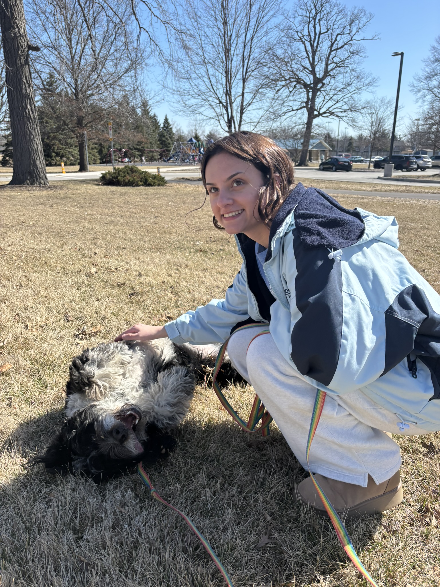Faith petting dog in a grassy yard